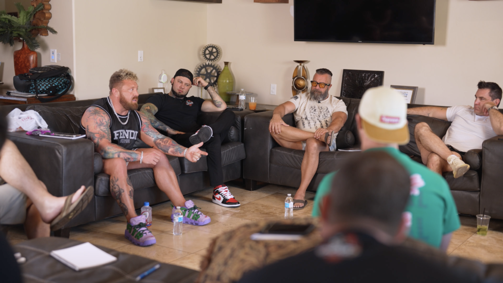 A group of men at the Uncaged Men’s Retreat engaging in deep discussions about accountability, personal growth, and business success in a relaxed, high-performance setting.
